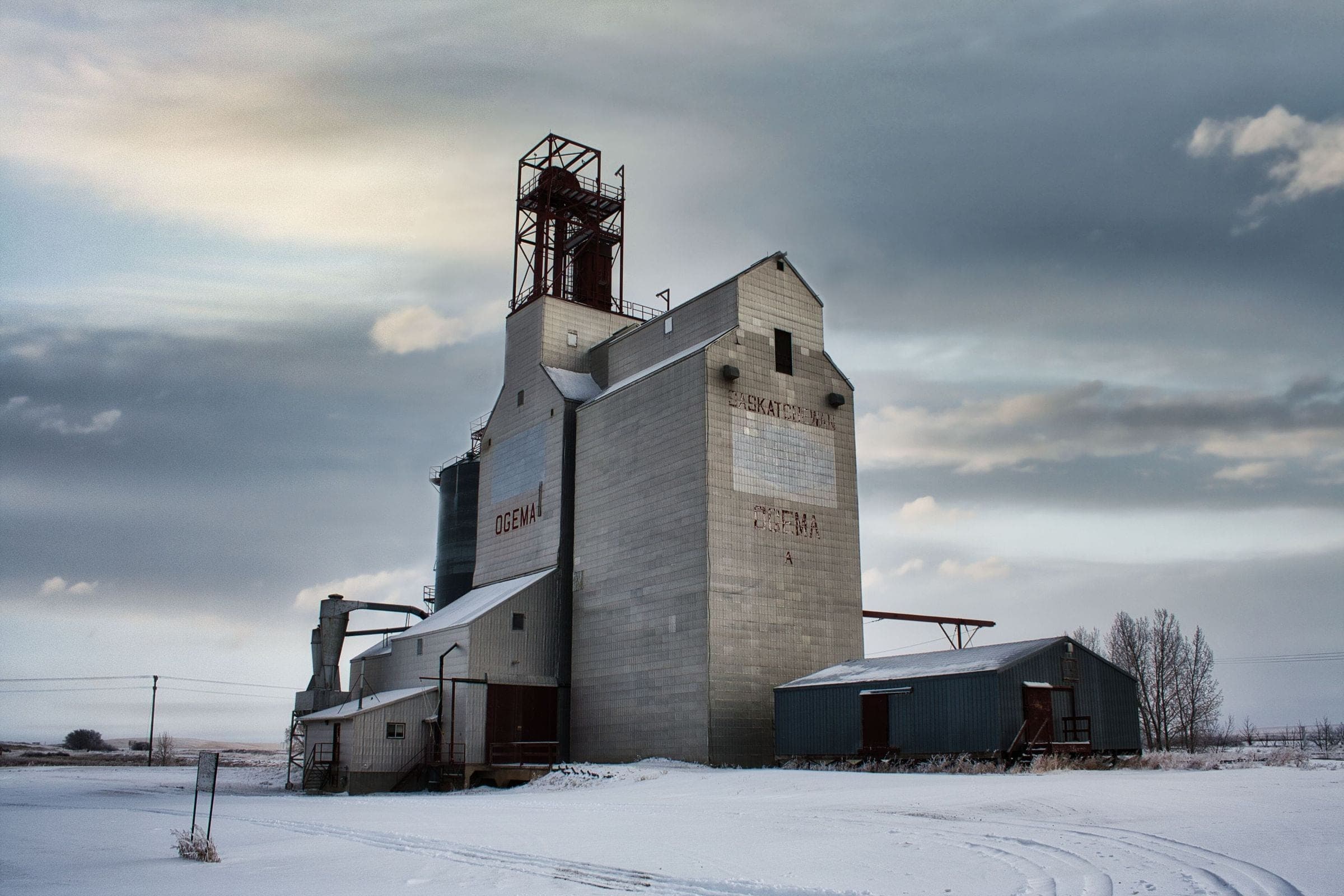 A grain elevator in a snowy prairie field, the kind of scene we serve for towing in Pense, SK